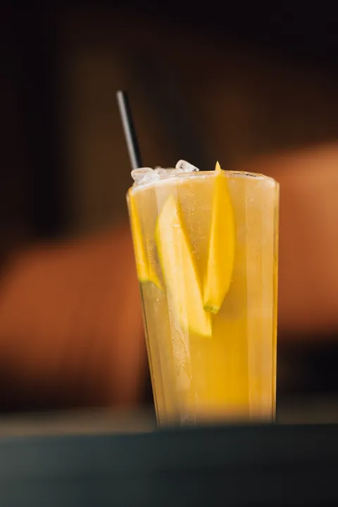 Un long drink jaune aux tranches de mangue