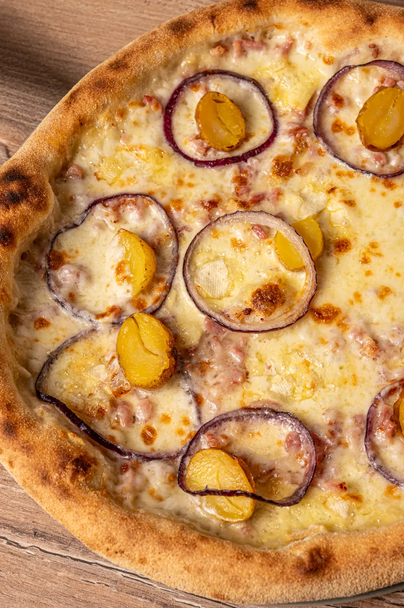 La pizza Montagnarde : reblochon, lardons, pommes de terre et oignons rouges