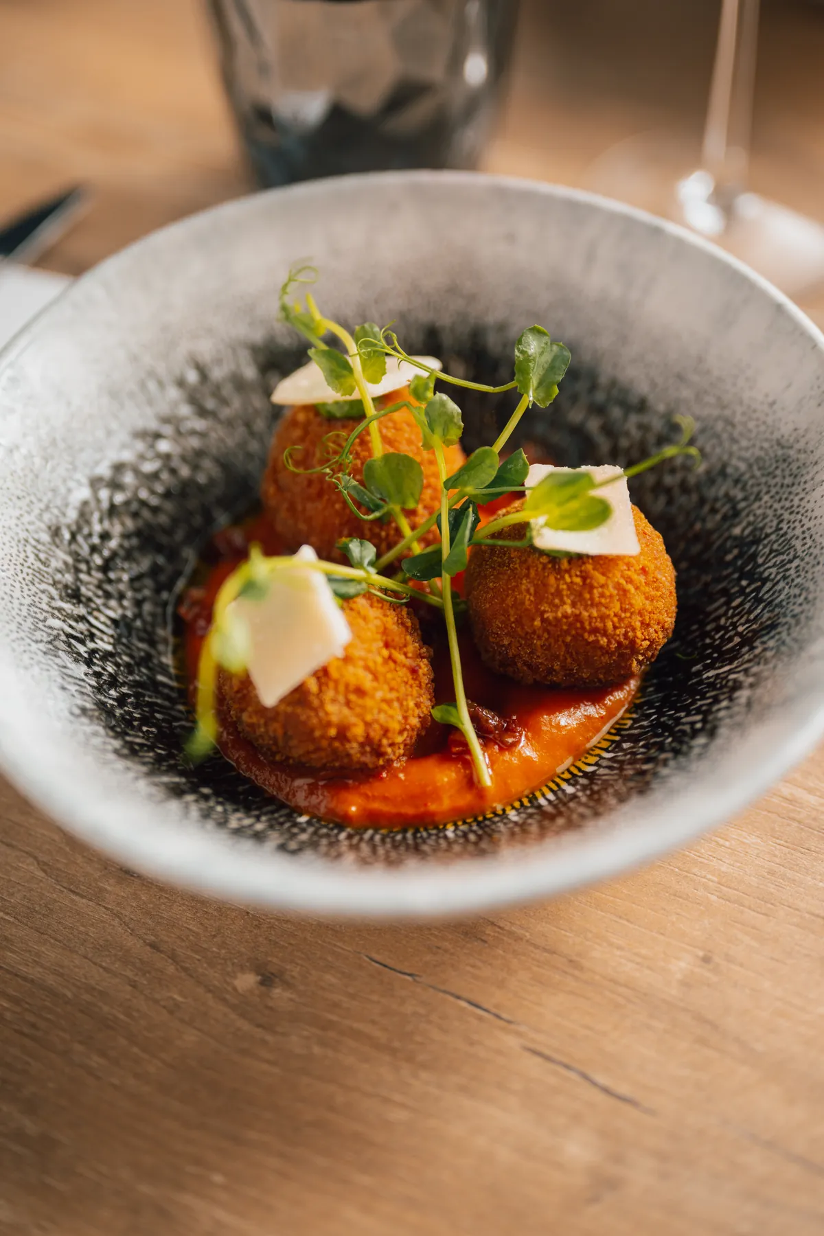 Des arancini croustillants sur un coulis de tomates