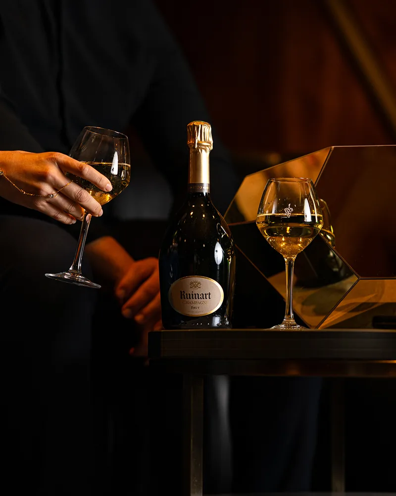Une bouteille de Ruinart et ses verres servis à table